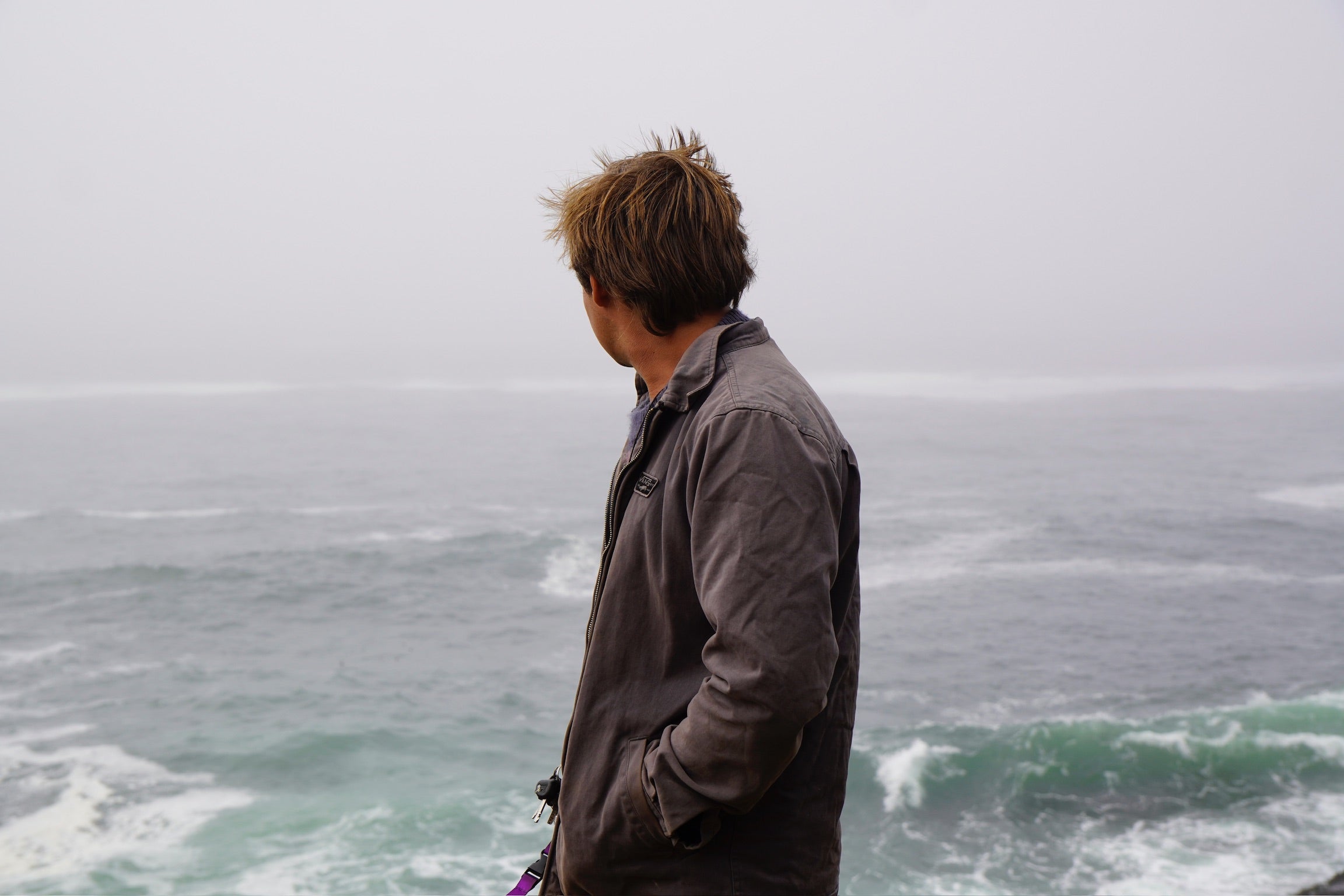 kylegoesoff standing on a cliff overlooking the ocean on a cloudy day